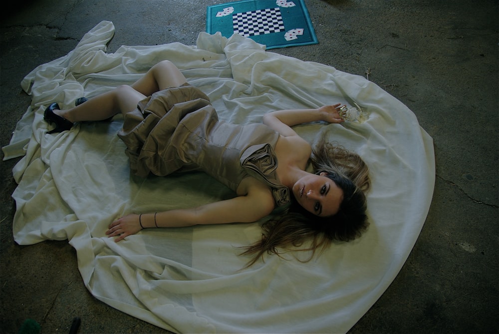 woman in gray sleeveless dress lying on ground