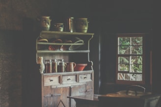 A charming farmhouse wooden hutch cabinet filled with rustic kitchenware and vintage accents.