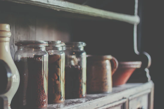 Cozy rustic workshop with wooden shelves displaying jars of roasted peanuts and artisanal snacks, bathed in warm natural light.