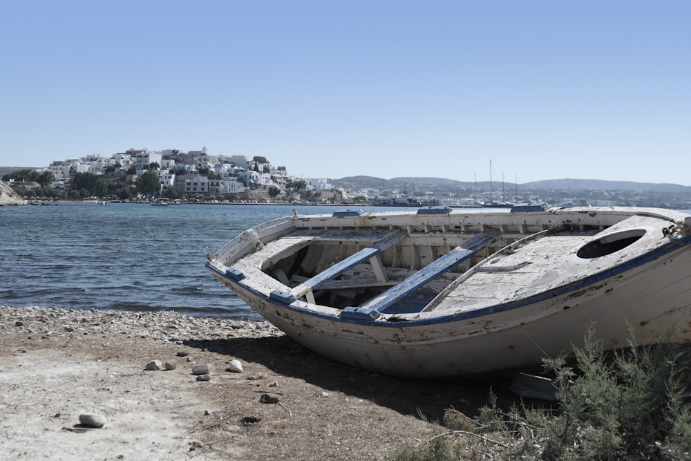 white rowboat on seashore