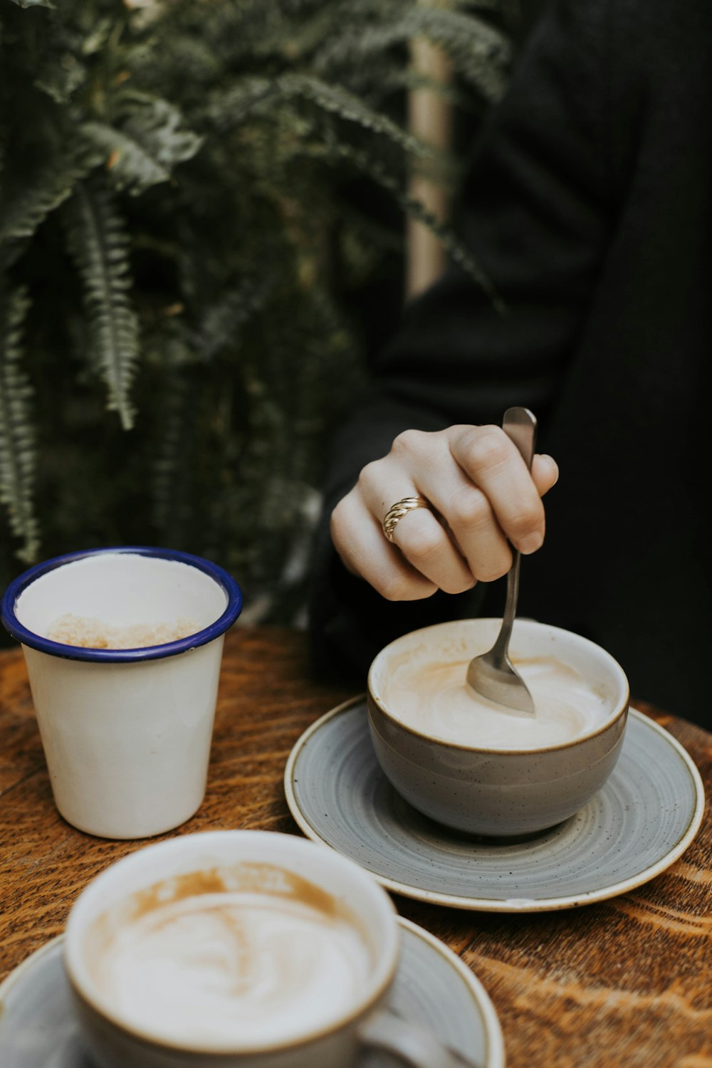 una persona sosteniendo una cuchara en una taza de café