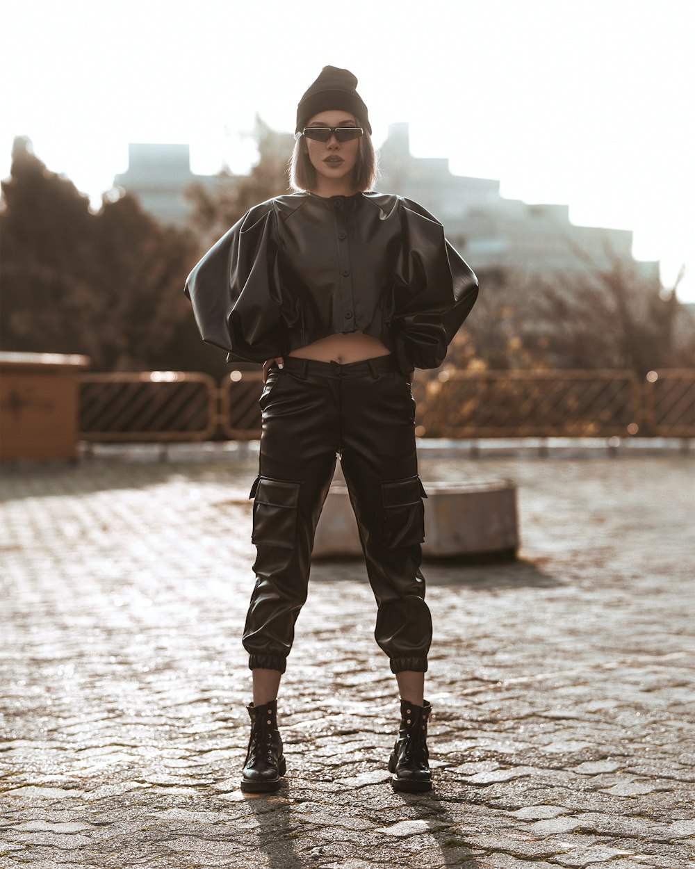 woman wearing black knit cap, black sunglasses, black leather jacket, black leather pants, and black leather biker boots