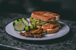 a white plate topped with a sandwich and a pickle