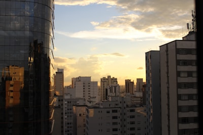 City skyline with various residential and commercial buildings at sunset.