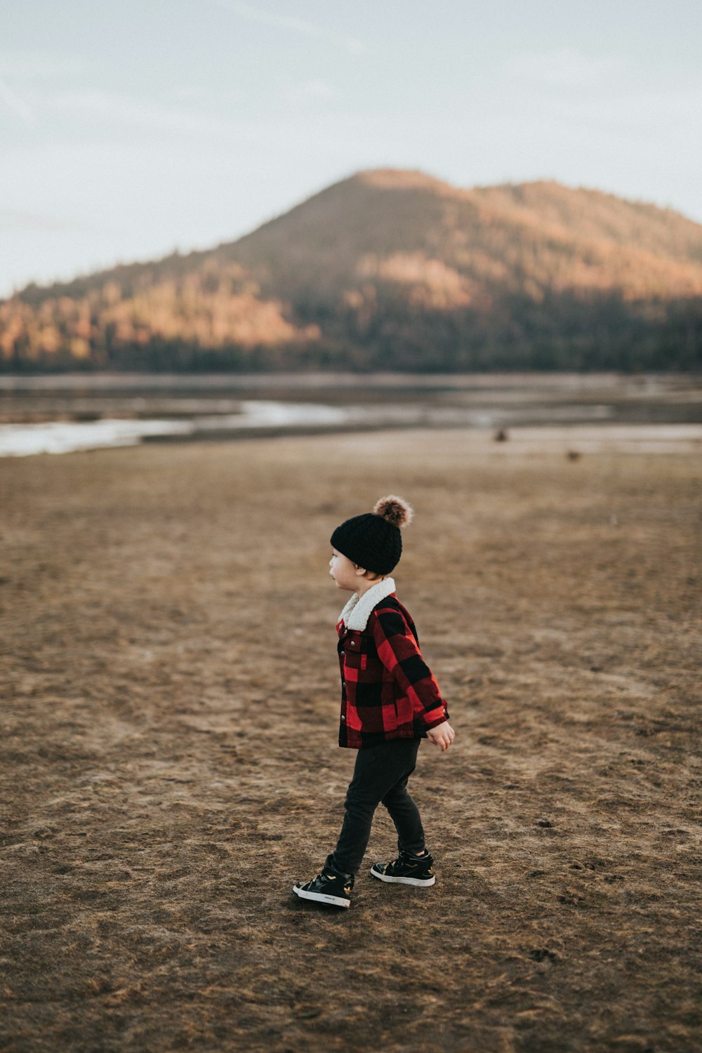 child walking on brown surface