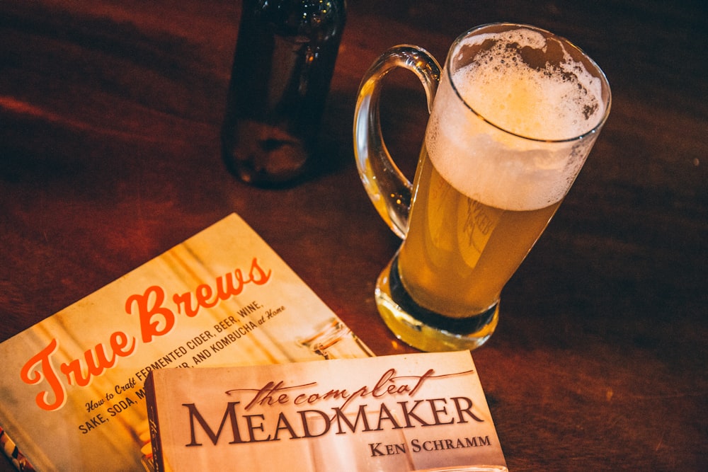 glass beer mug by stacked books