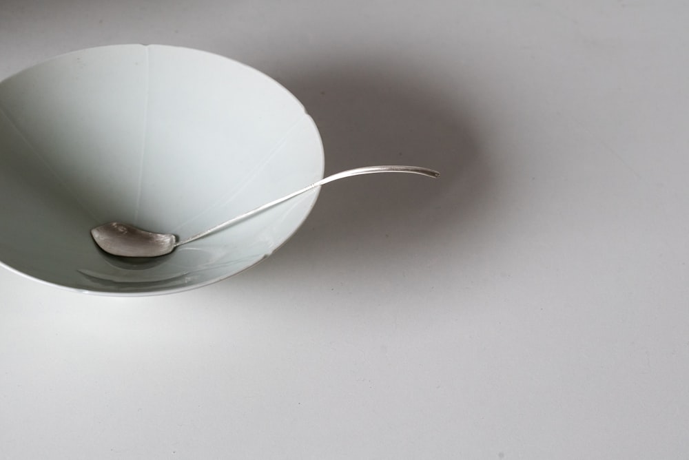 soup ladle in bowl on white surface