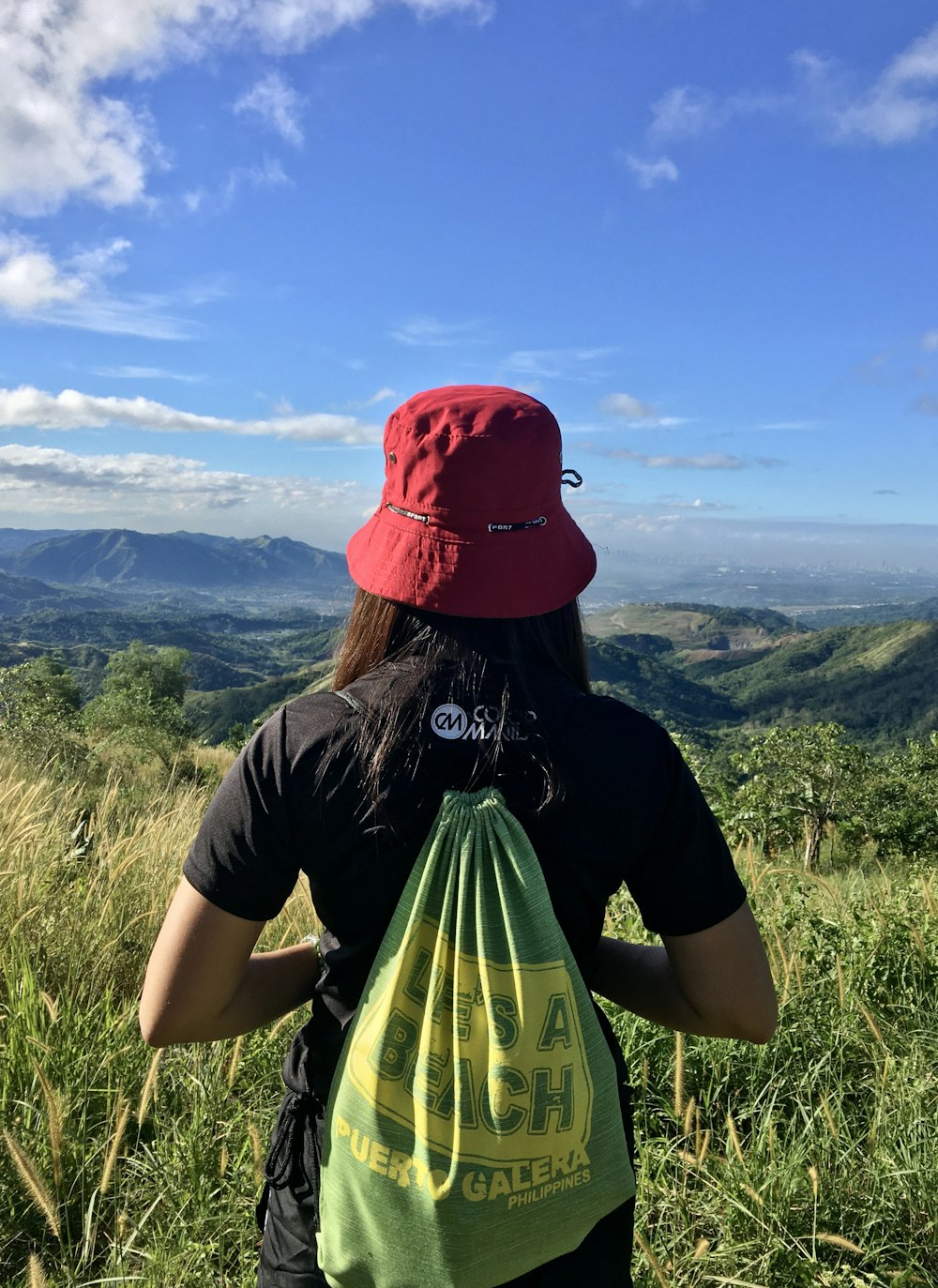 woman with bag facing mountains during daytime