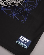 A detailed view of a black fabric featuring a complex geometric pattern in blue and white lines on the upper portion. A stitched label is present in the lower corner with the words 'KIKII' and some additional text in Japanese characters along with the word 'AWAKEN'.