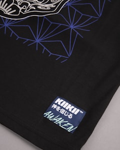 A detailed view of a black fabric featuring a complex geometric pattern in blue and white lines on the upper portion. A stitched label is present in the lower corner with the words 'KIKII' and some additional text in Japanese characters along with the word 'AWAKEN'.