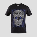 A black T-shirt features an intricate skull design with floral and geometric patterns in white and blue. The skull is stylized with ornate details highlighting the eyes, nose, and mouth, creating a visually striking effect against the dark fabric.