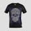 A black T-shirt features an intricate skull design with floral and geometric patterns in white and blue. The skull is stylized with ornate details highlighting the eyes, nose, and mouth, creating a visually striking effect against the dark fabric.