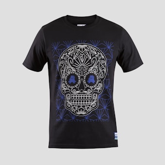 A black T-shirt features an intricate skull design with floral and geometric patterns in white and blue. The skull is stylized with ornate details highlighting the eyes, nose, and mouth, creating a visually striking effect against the dark fabric.