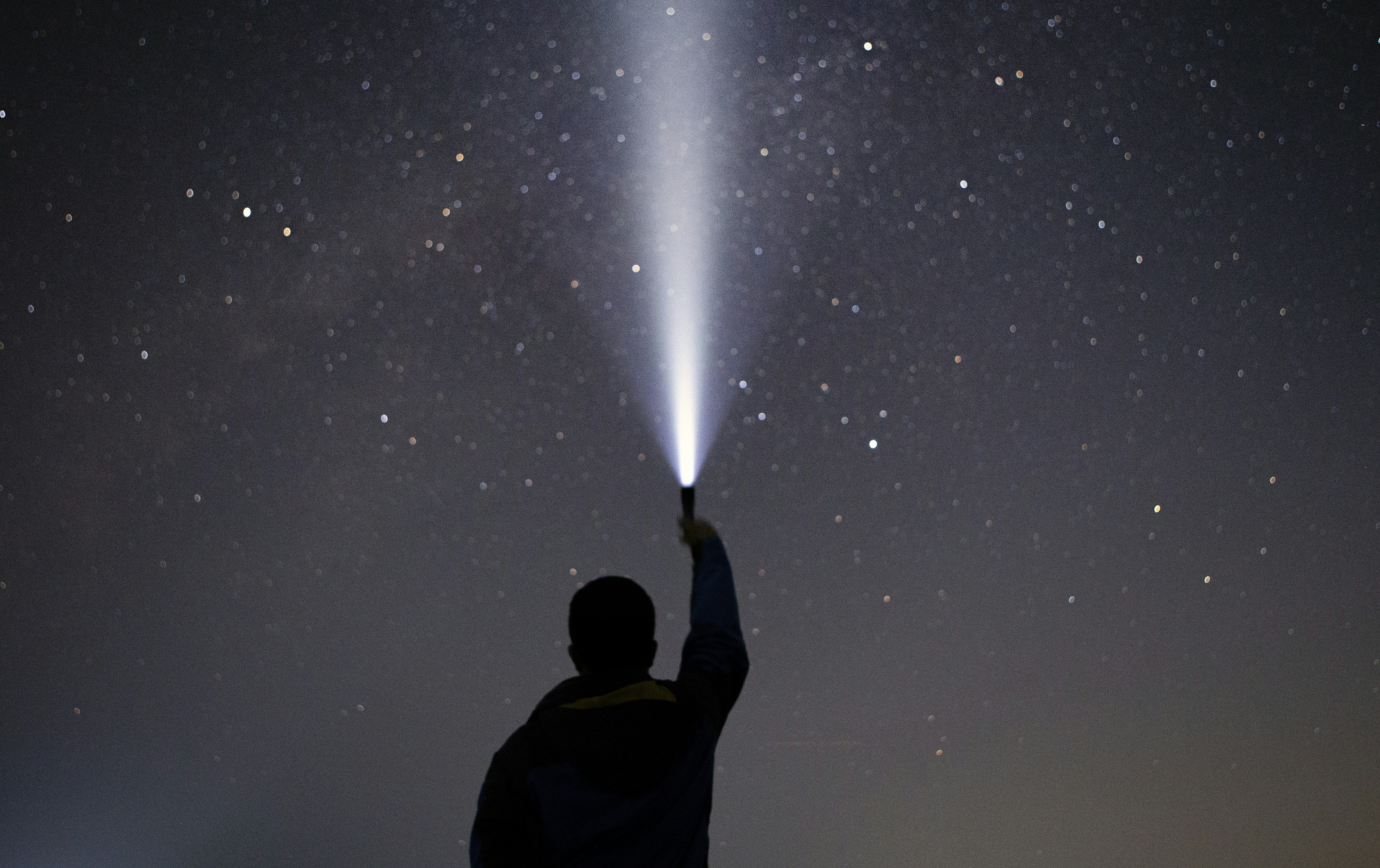 man raising flashlight