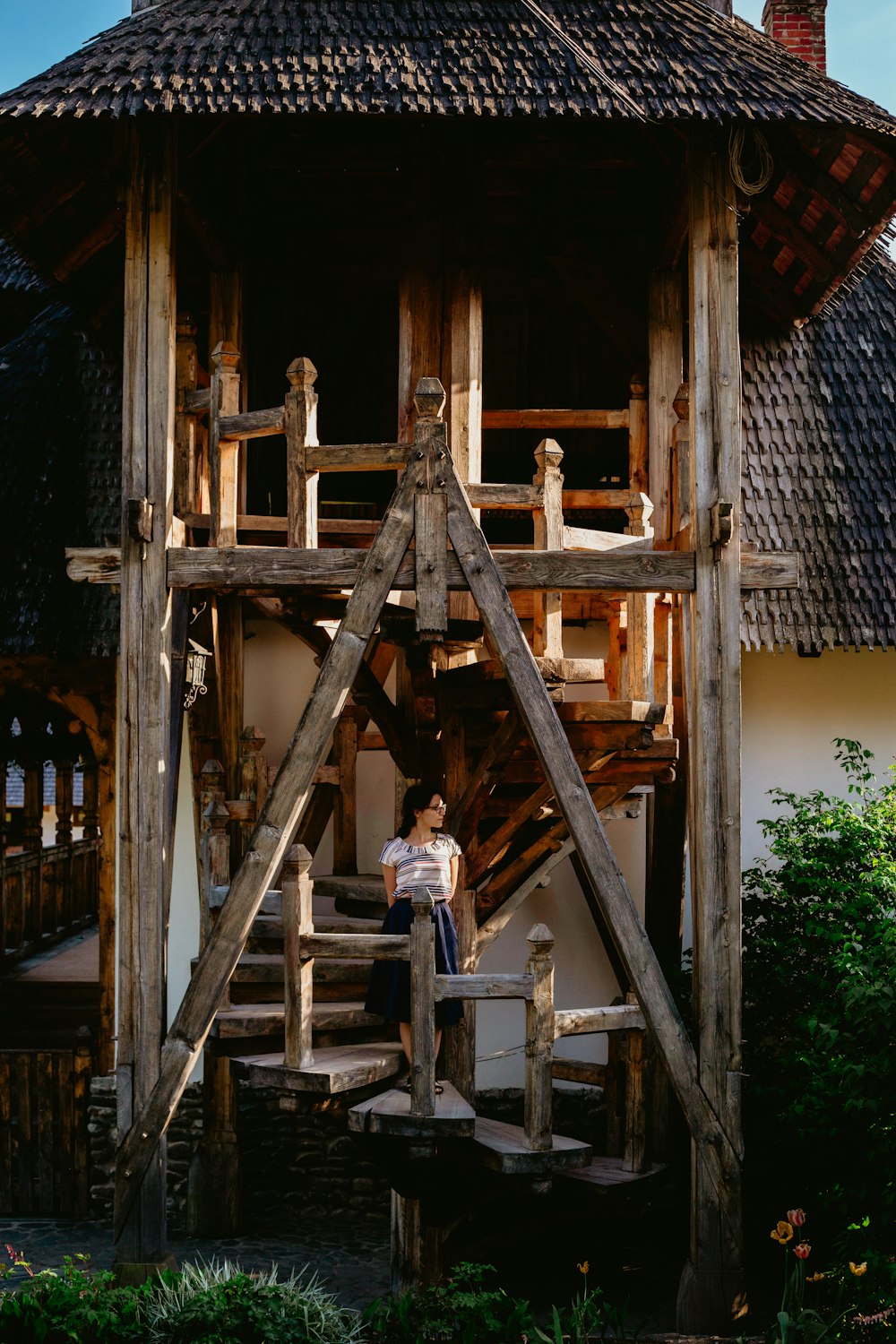 woman standing on wooden spiral stairs