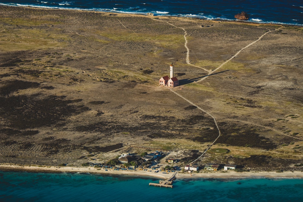 aerial photography of houses on green field near body of water