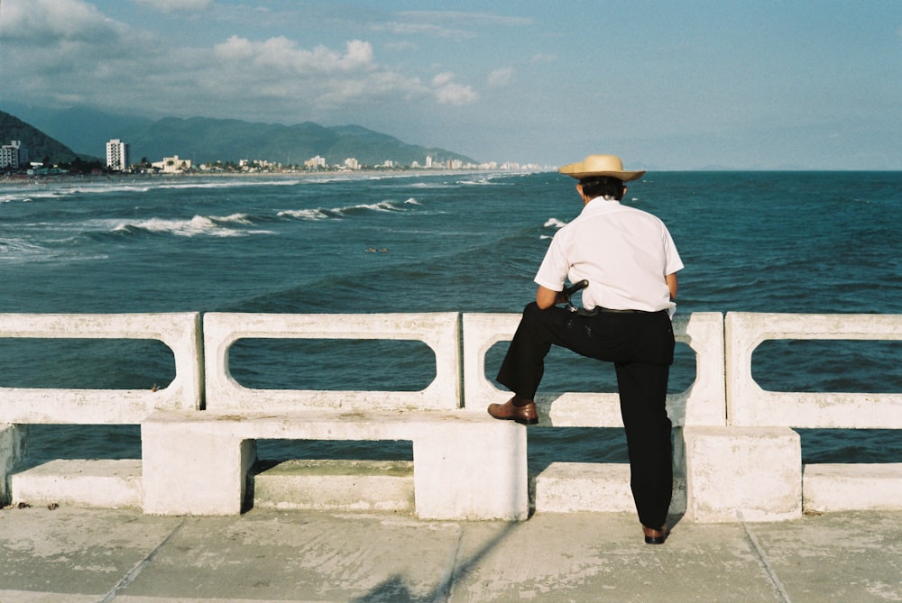 Mann steht in der Nähe von Betonbalustrade neben Gewässer