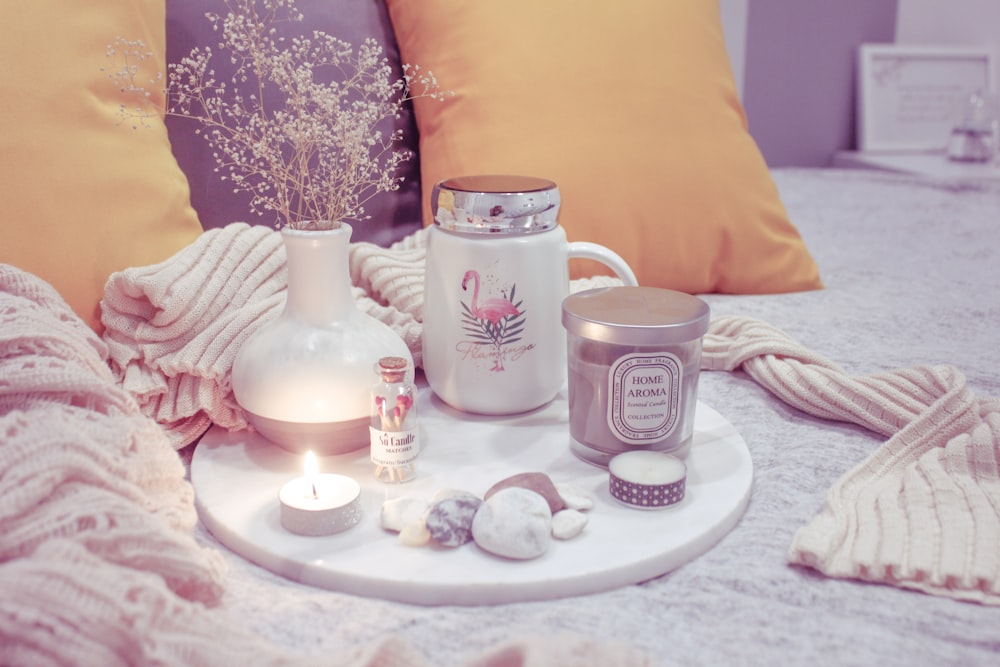 candle tealight beside jar on white board