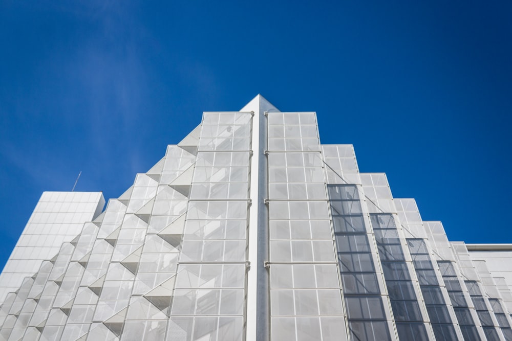 a tall white building with a blue sky in the background