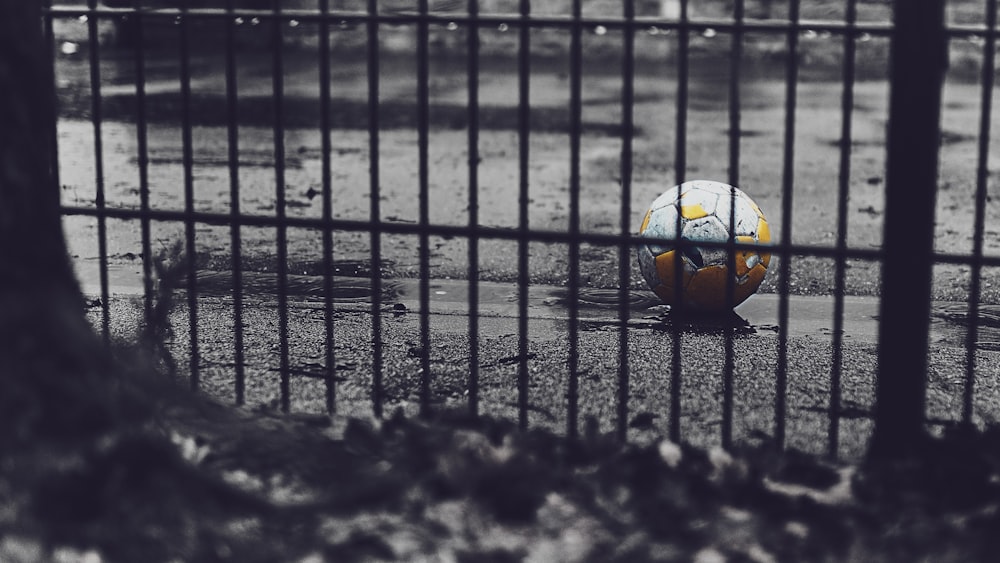 Balón de fútbol naranja y verde en la carretera