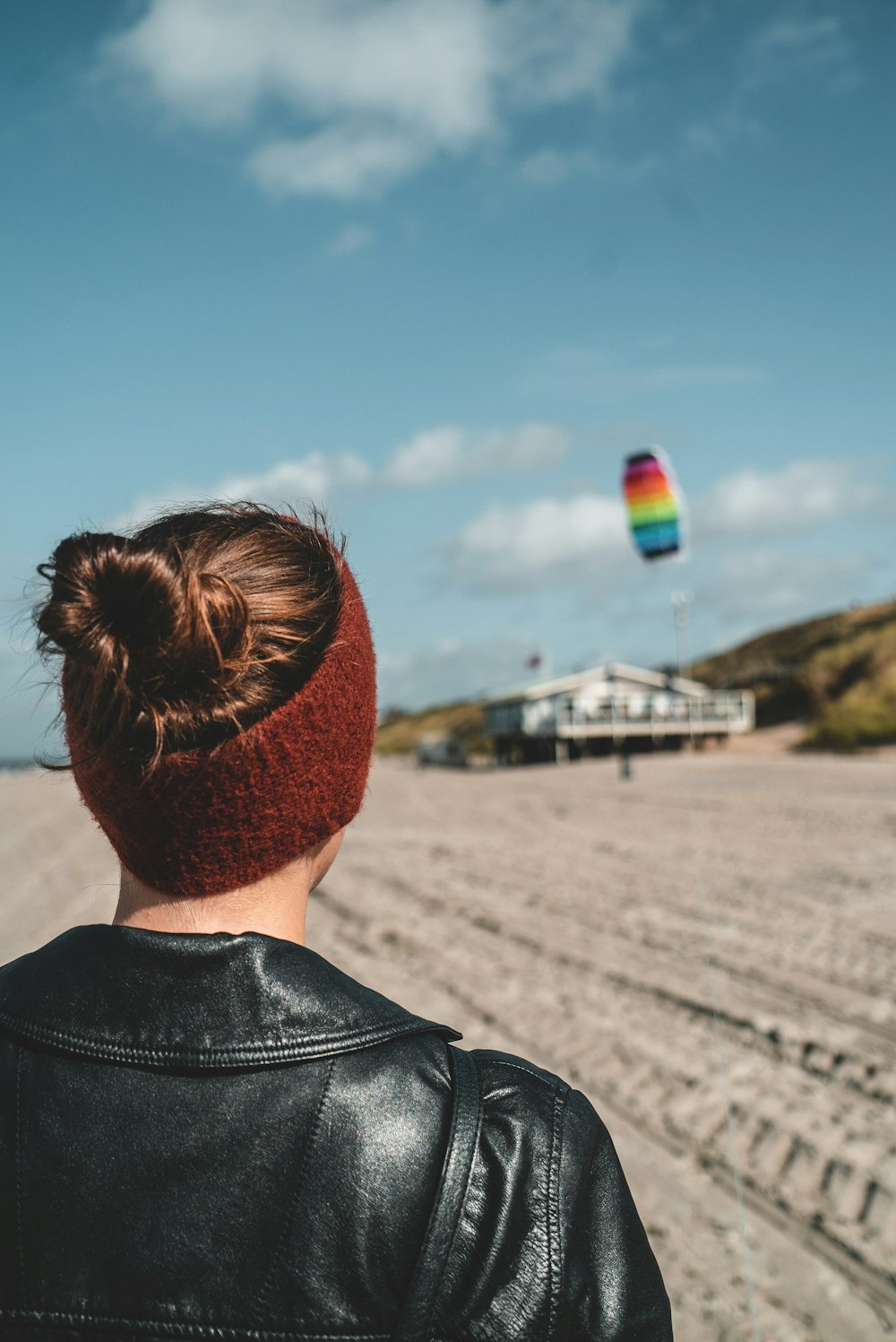 person wearing black leather jacket standing on desert