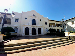 Elegant university building facade with green and white accents in historic Barranquilla neighborhood.