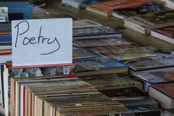 A poster with "poetry" written on it is placed on top of books