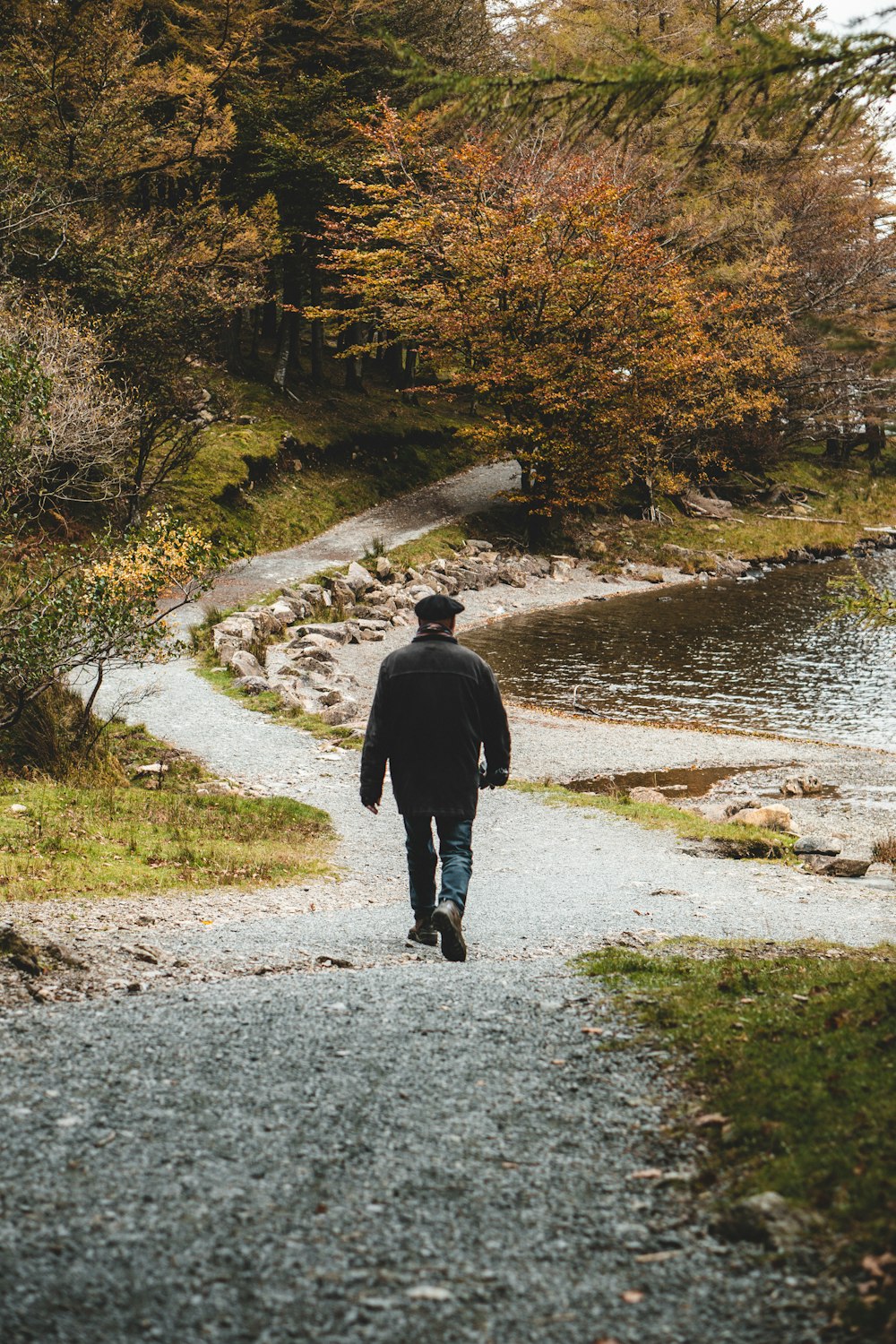 person walking beside body of water