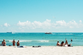 Happy travelers enjoying the sun on a white sandy beach in the Bahamas.