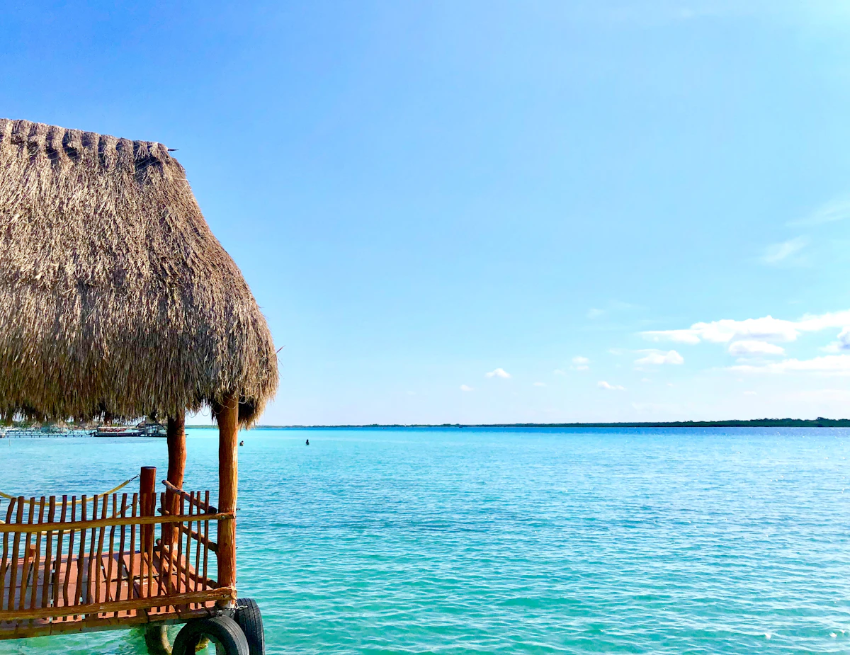 Kayaks on calm turquoise water of a Mexican lagoon surrounded by tropical vegetation