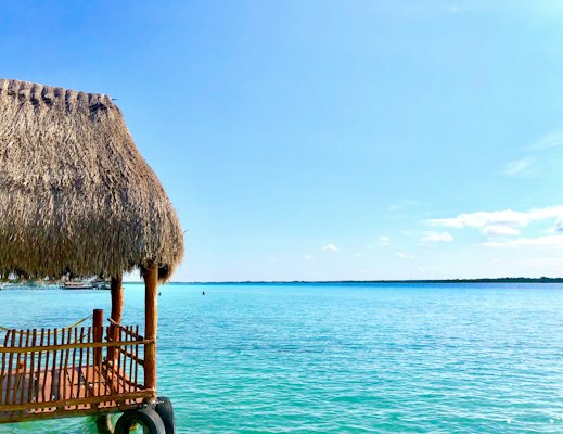 Thatch hut above the sea during day — Bacalar, Mexico