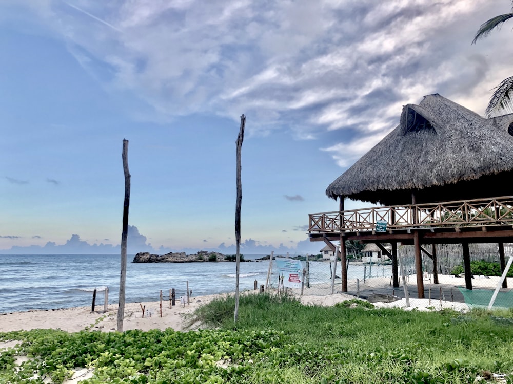 a hut on a beach next to the ocean