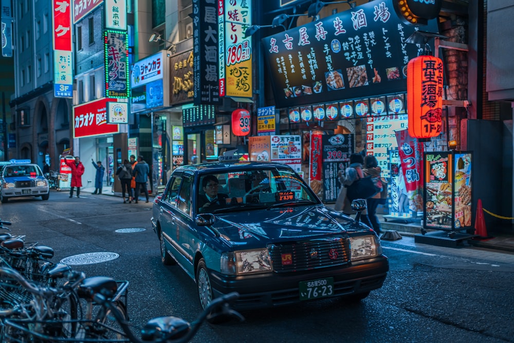 blue sedan on road at night