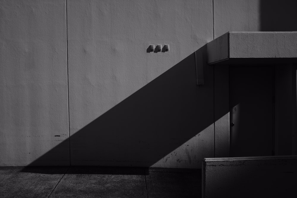 a black and white photo of a bench and a wall