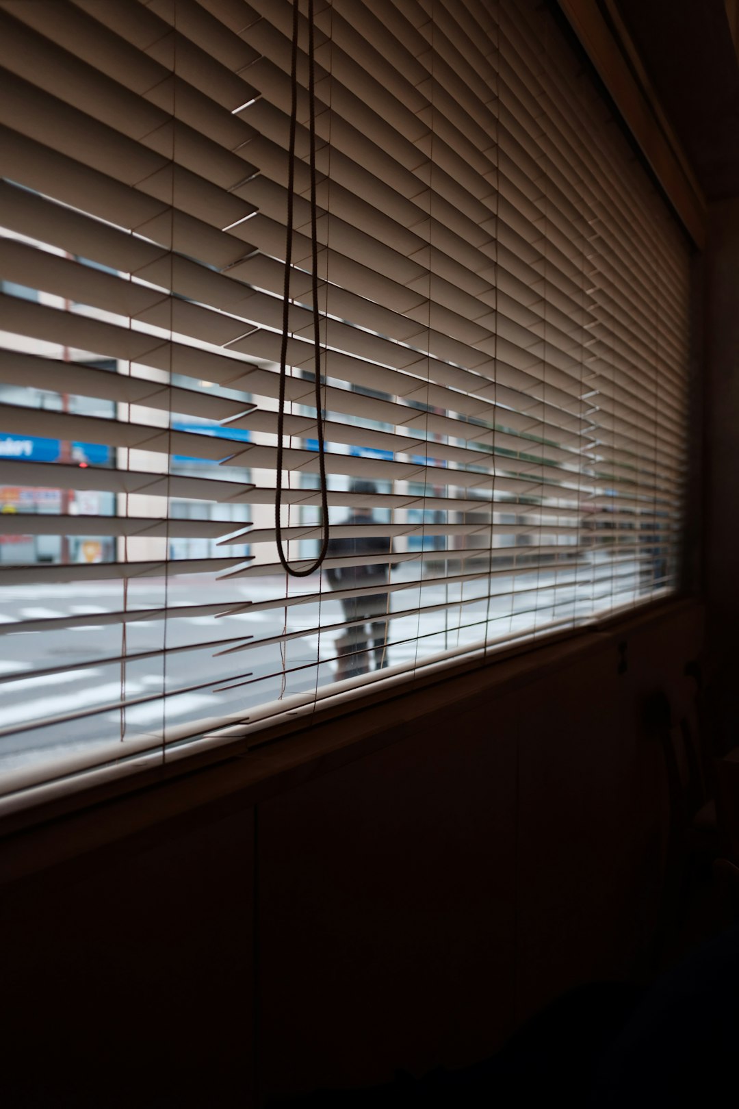 boy walking near white venetian blinds