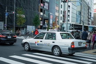 A taxi waiting at a curb with a city backdrop.