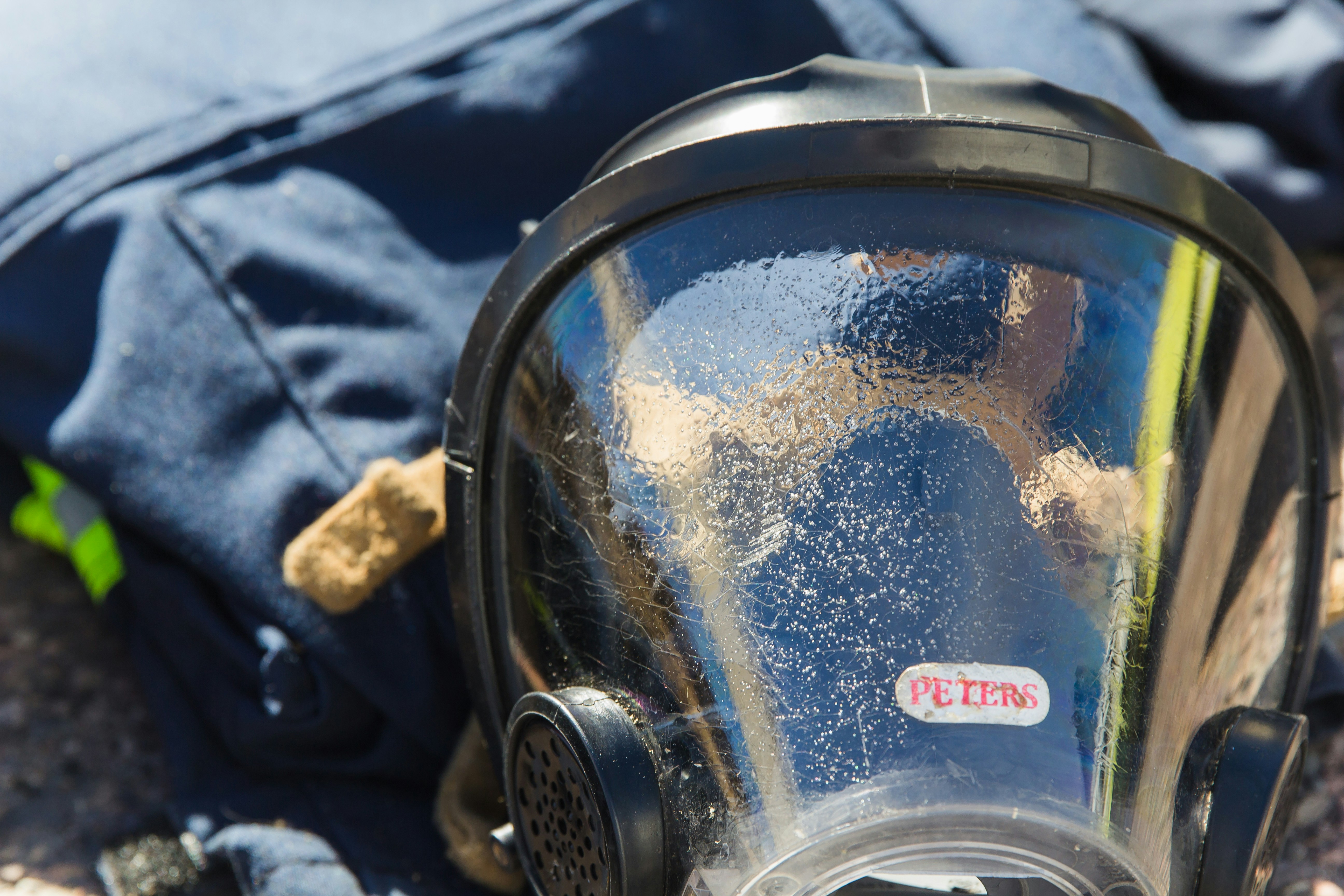 a gas mask sitting on the ground next to a backpack