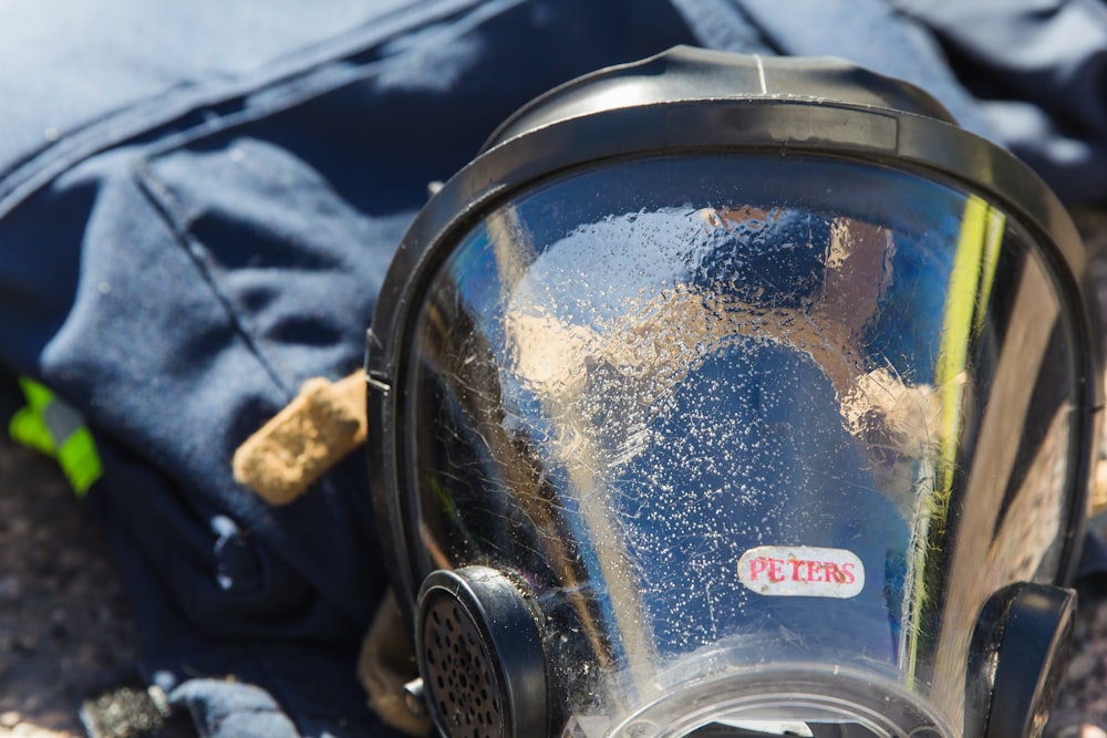 a gas mask sitting on the ground next to a backpack