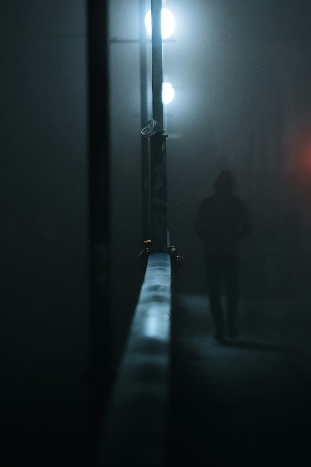 a person walking down a hallway in the dark