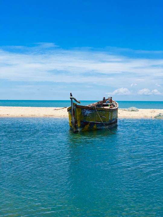 brown canoe on water in Dhanushkodi India