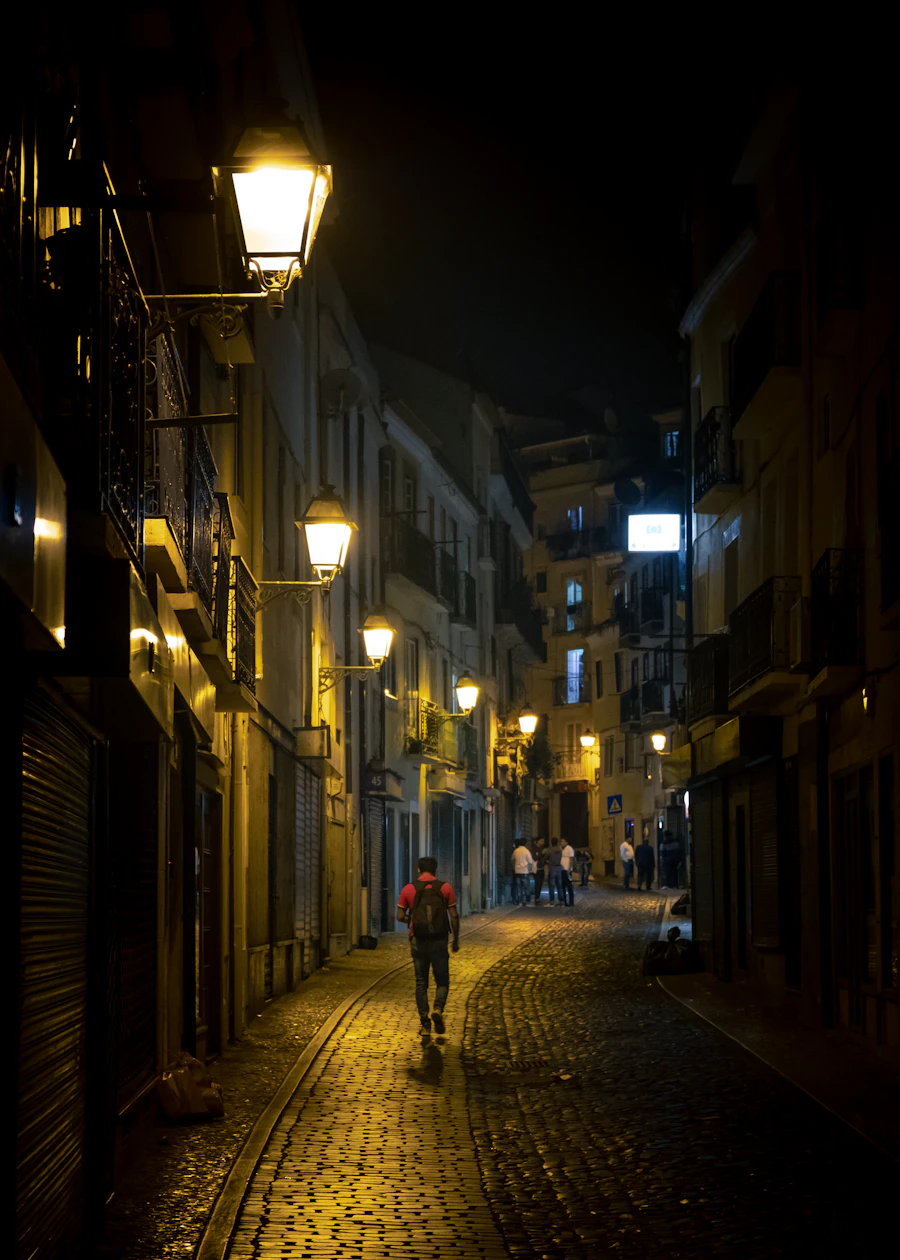 A man walking down a cobblestone street at night