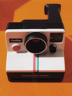 white and black Polaroid OneStep land camera