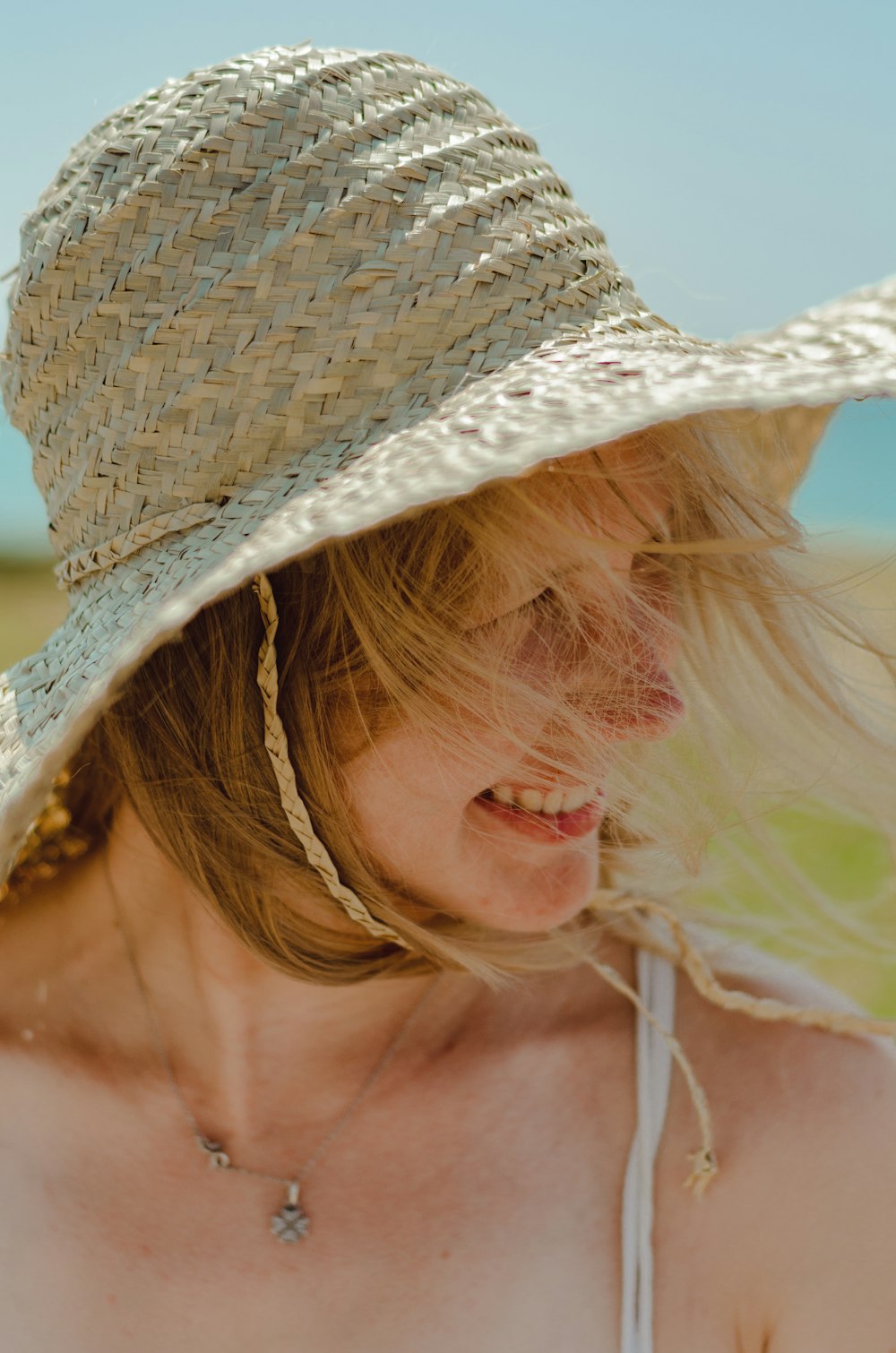 smiling woman wearing gray sun hat