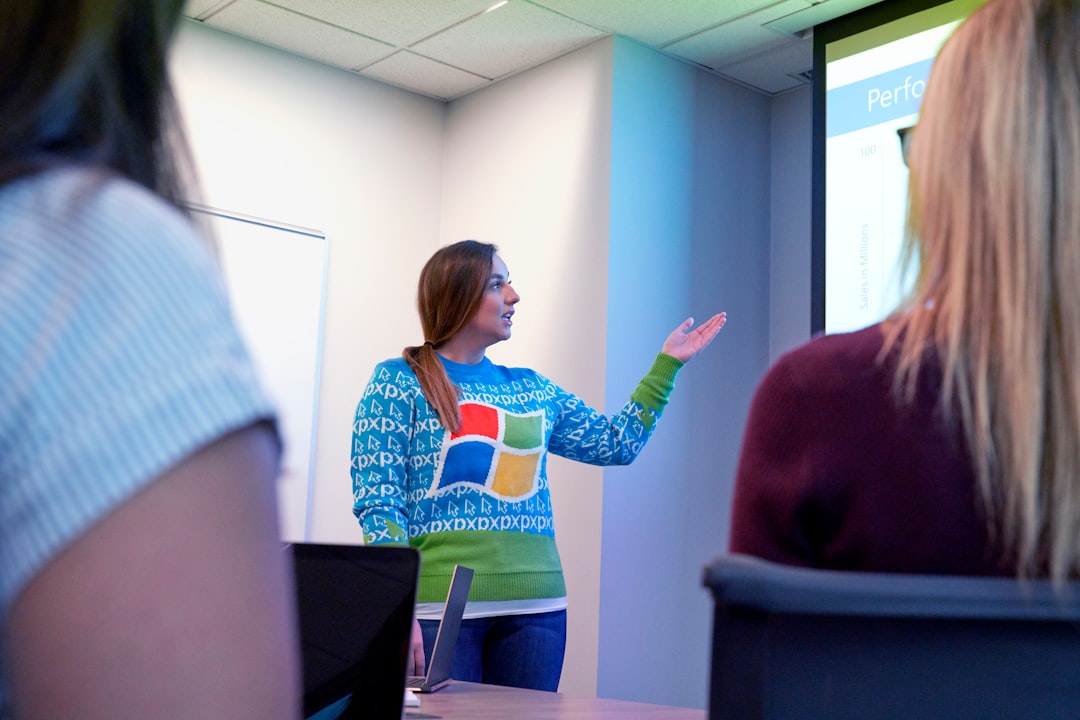 woman in blue sweater standing beside projector screen