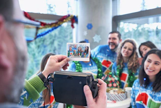 Guests happily holding freshly printed photo strips from a photo booth at a festive event.