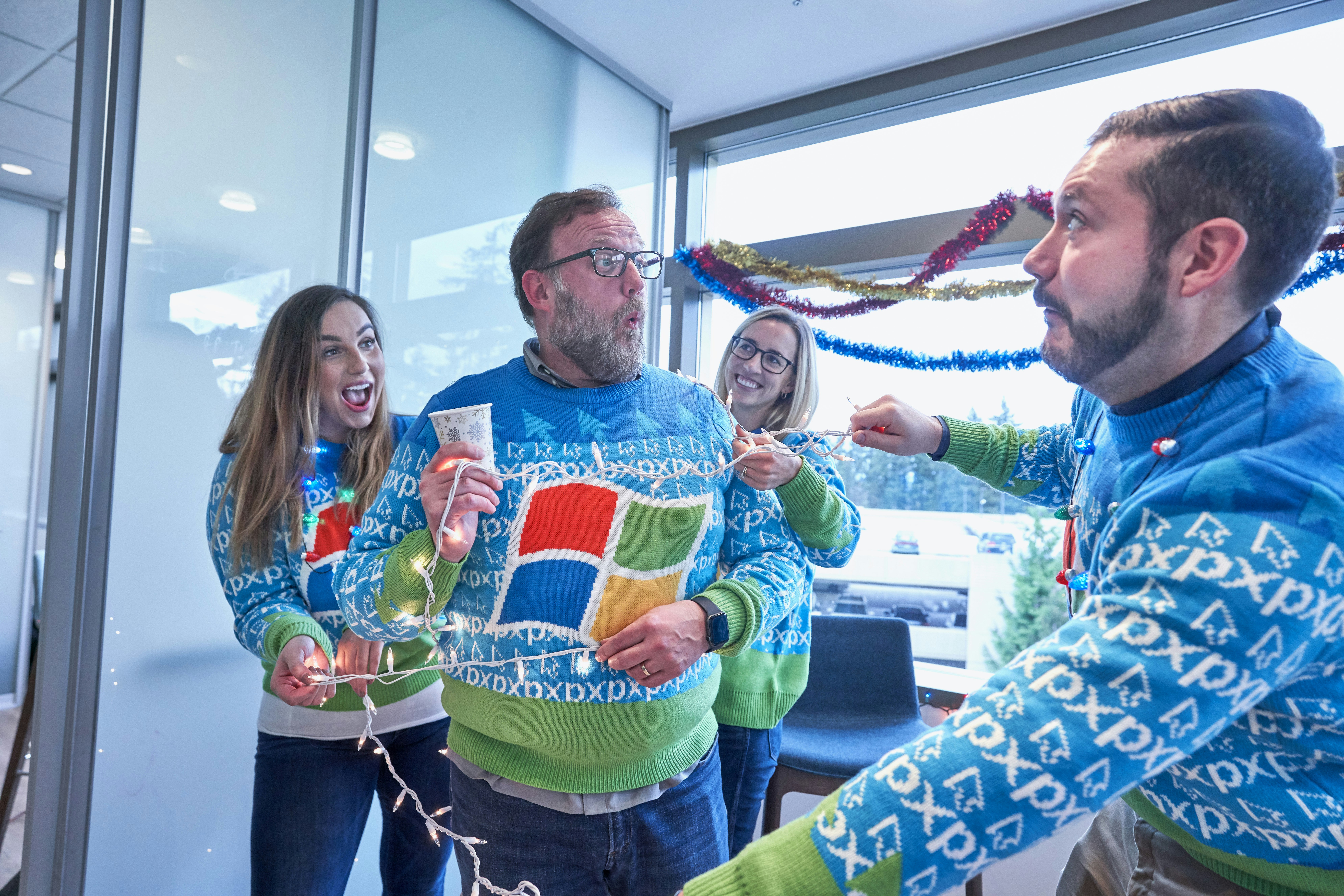 man in blue sweater holding light string