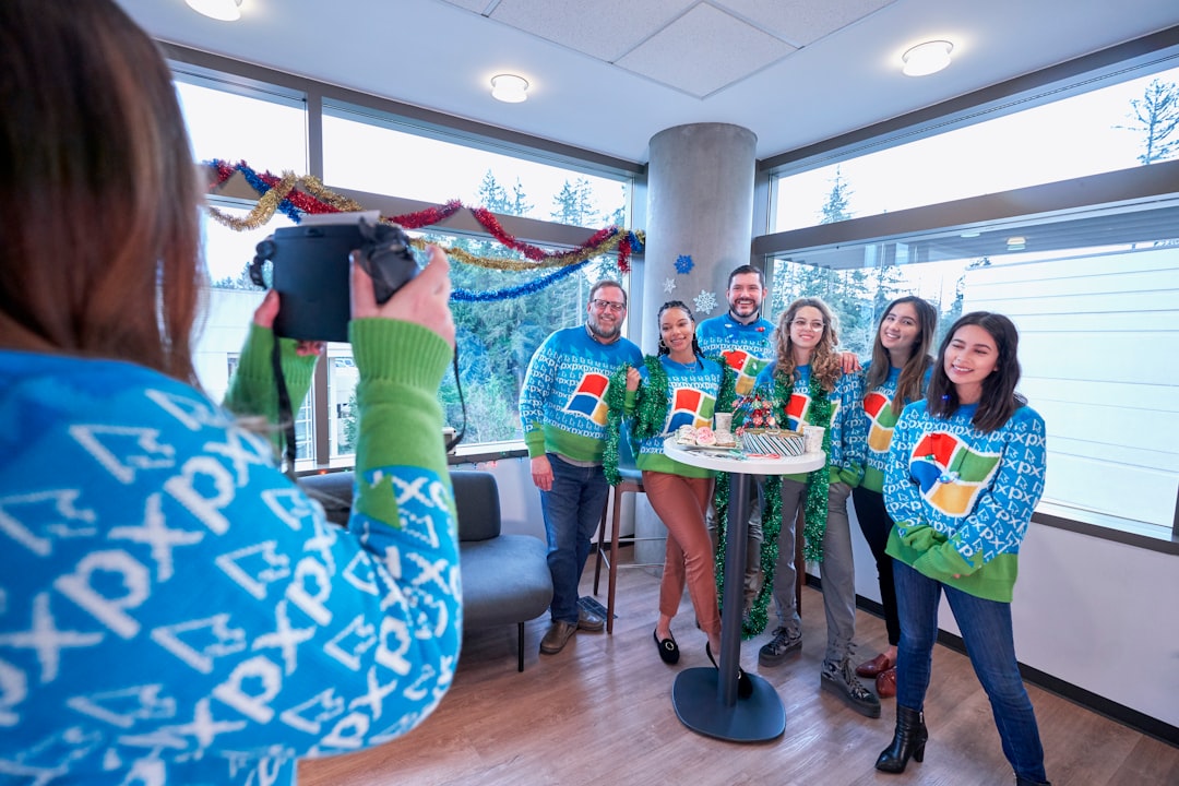 woman taking picture of family wearing Windows XP sweater inside well-lit room