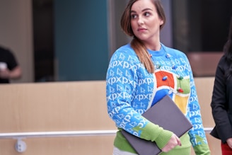 A stylish woman reaching out to a laptop for assistance.
