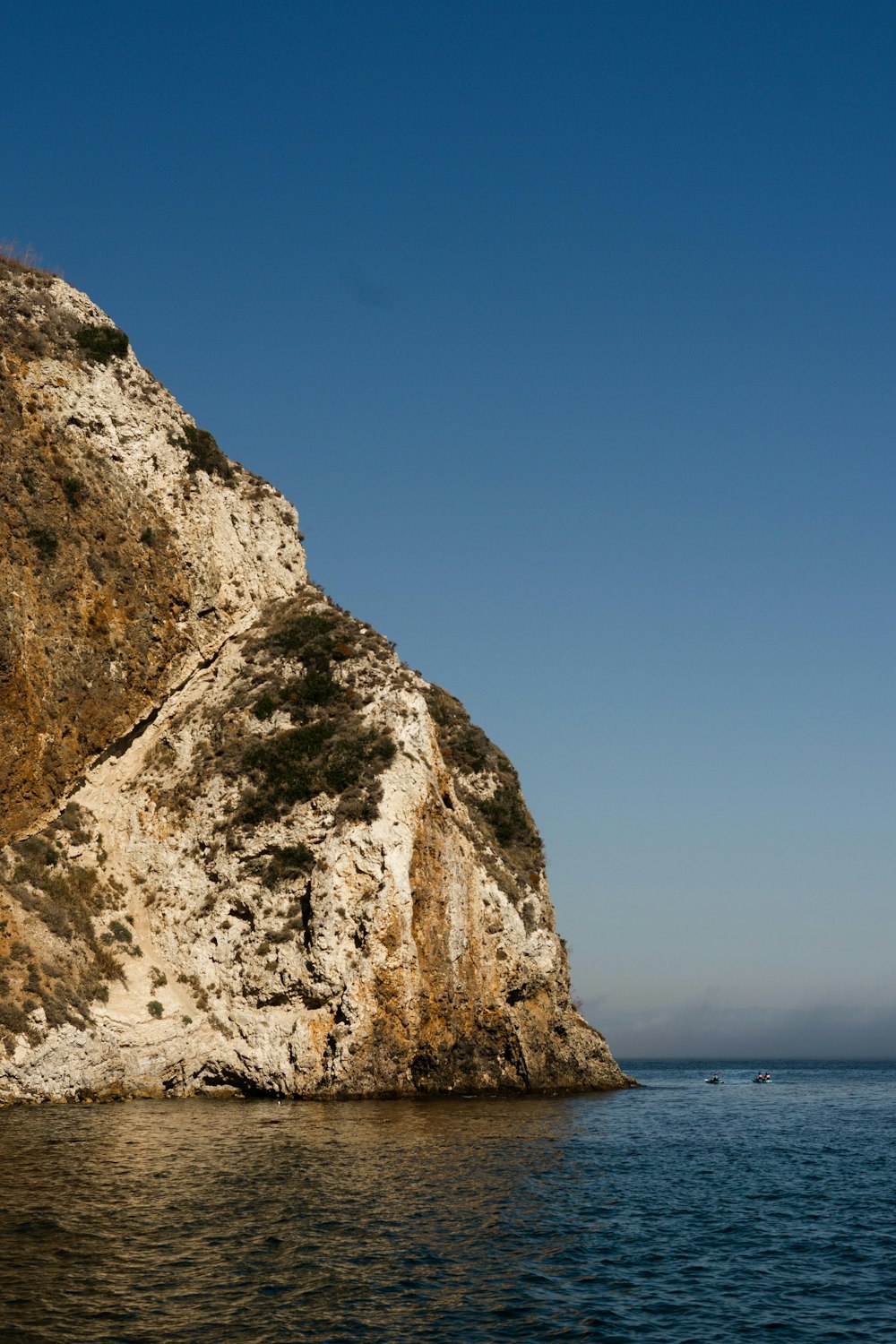 view photography of gray and brown stone mountain and sea during daytime