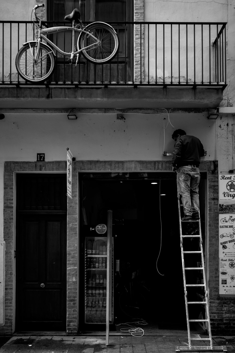 grayscale photography of man on ladder